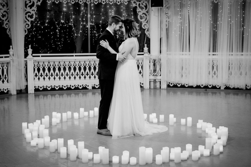 a bride and groom dance surrounded by a ring of hundreds of candles