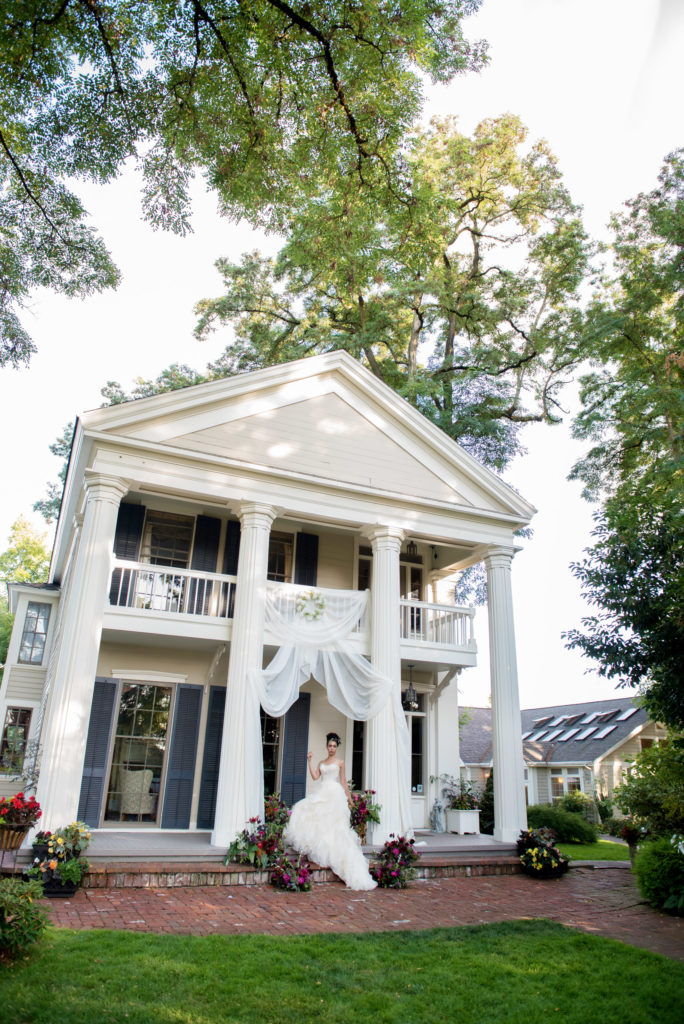bride stands on front steps of house at ainsworth house and gardens 