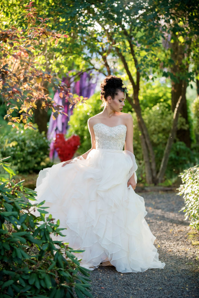 bride in ruffled wedding dress walks through sculpture forest