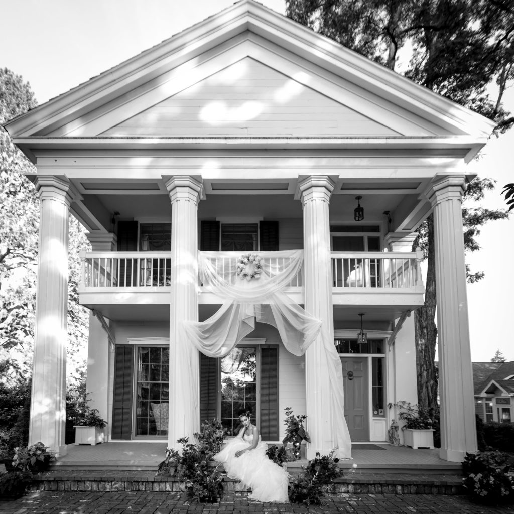 bride sits on front steps of house at ainsworth house and gardens 