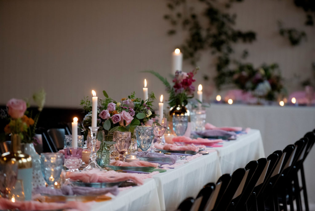 pastel wedding reception table with pastel goblets and lots of candles
