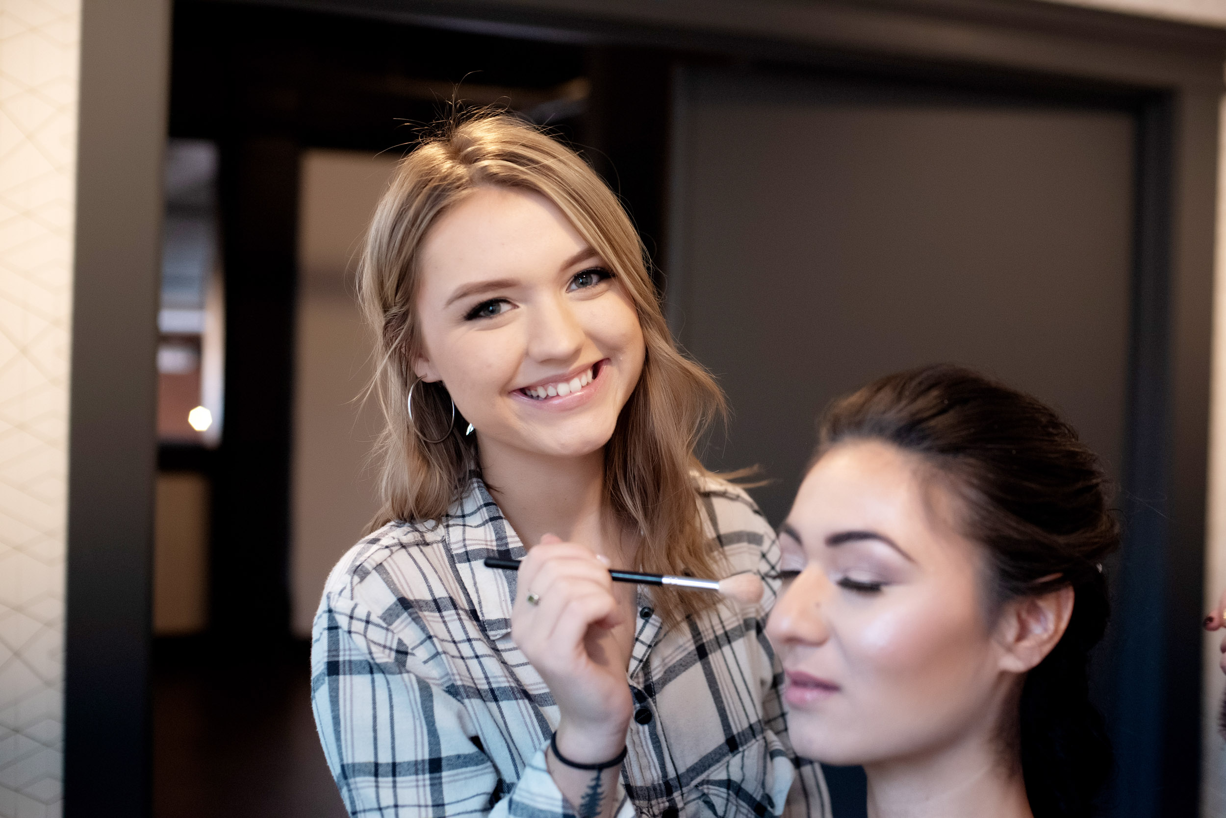 shelby renee applies makeup to a bride at the evergreen