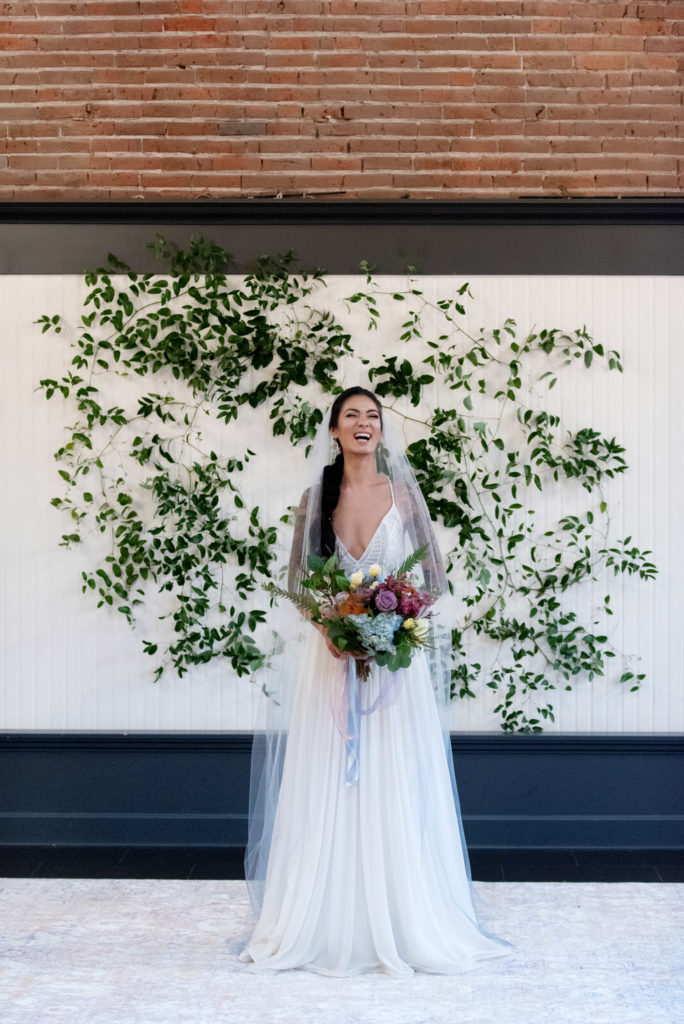 bride wears a blue ombre veil and a low cut v-neck wedding dress from a&be bridal