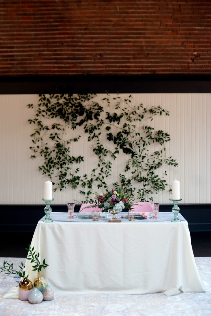pastel sweetheart table with smilax backdrop 