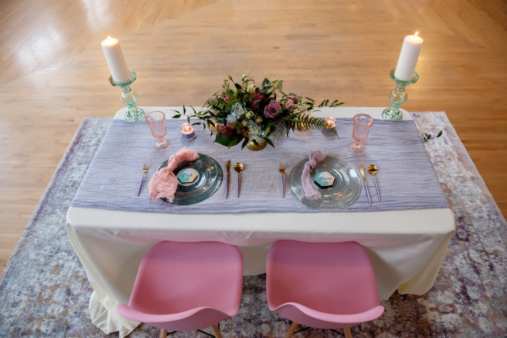 hand dyed purple cheesecloth runner and purple cheesecloth napkins on a sweetheart table where vinyl records are used as chargers for the bride and groom 